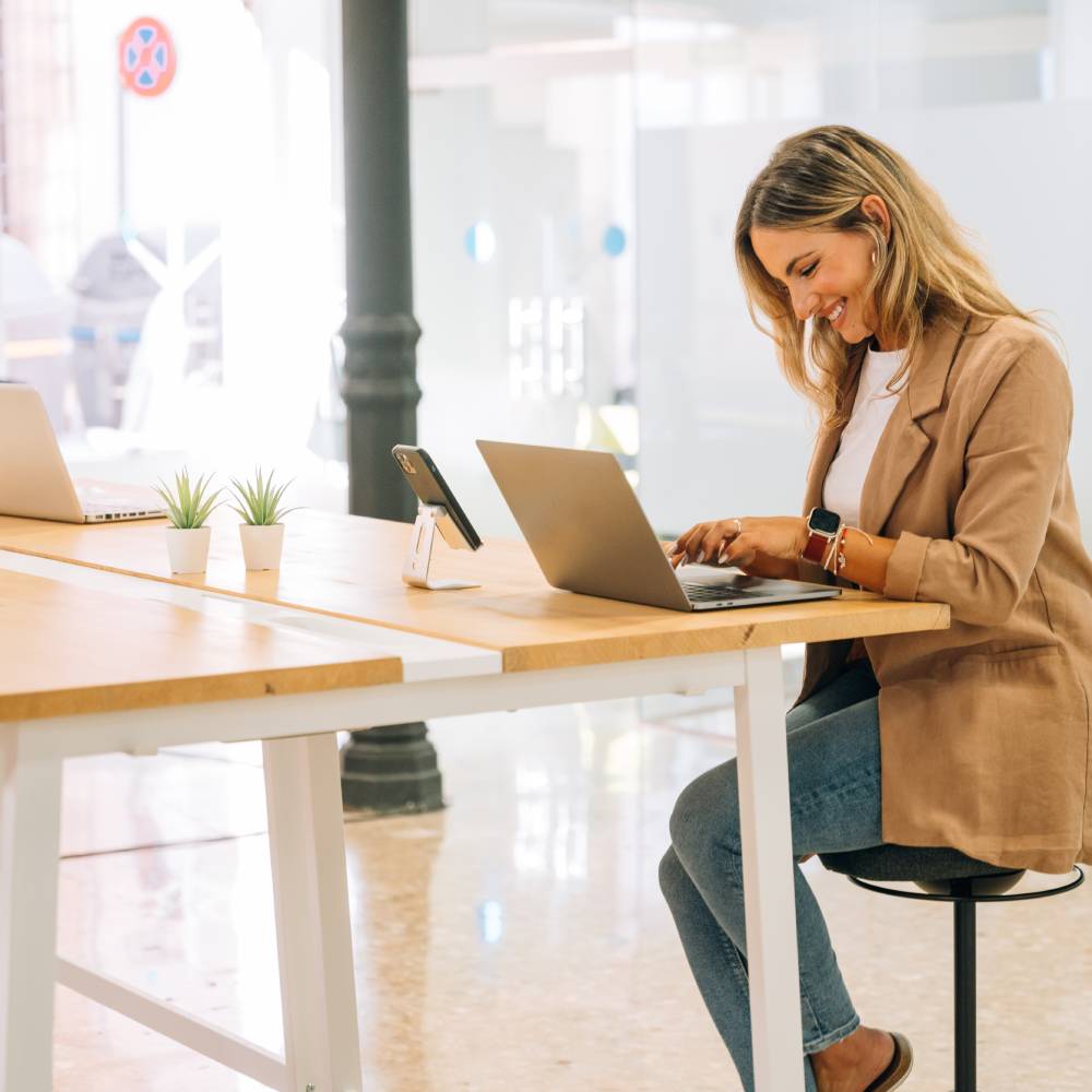 Espacio de coworking con mesas de trabajo y sillas cómodas en un entorno profesional.
